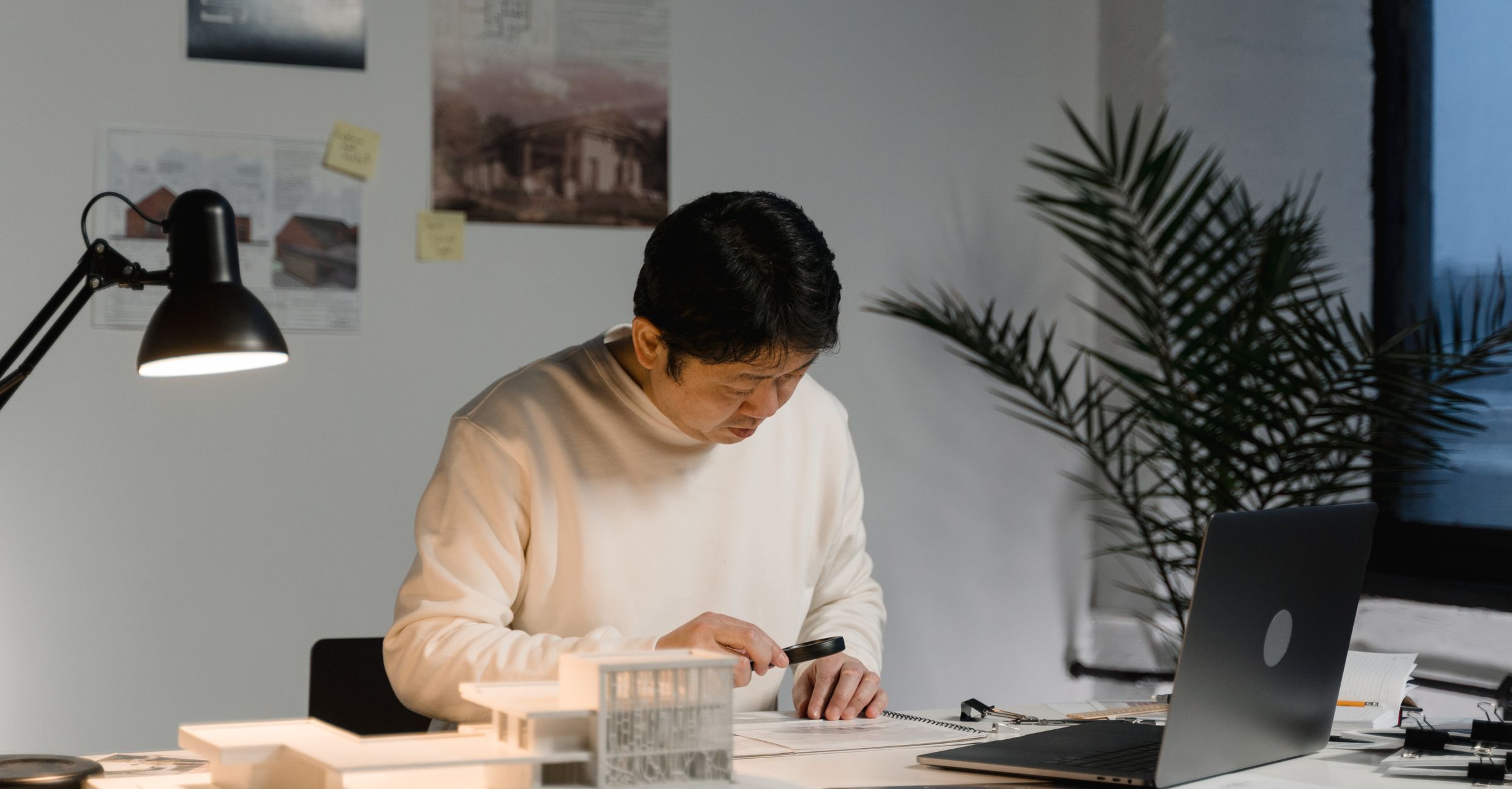 Architect working at a desk with building models and documents