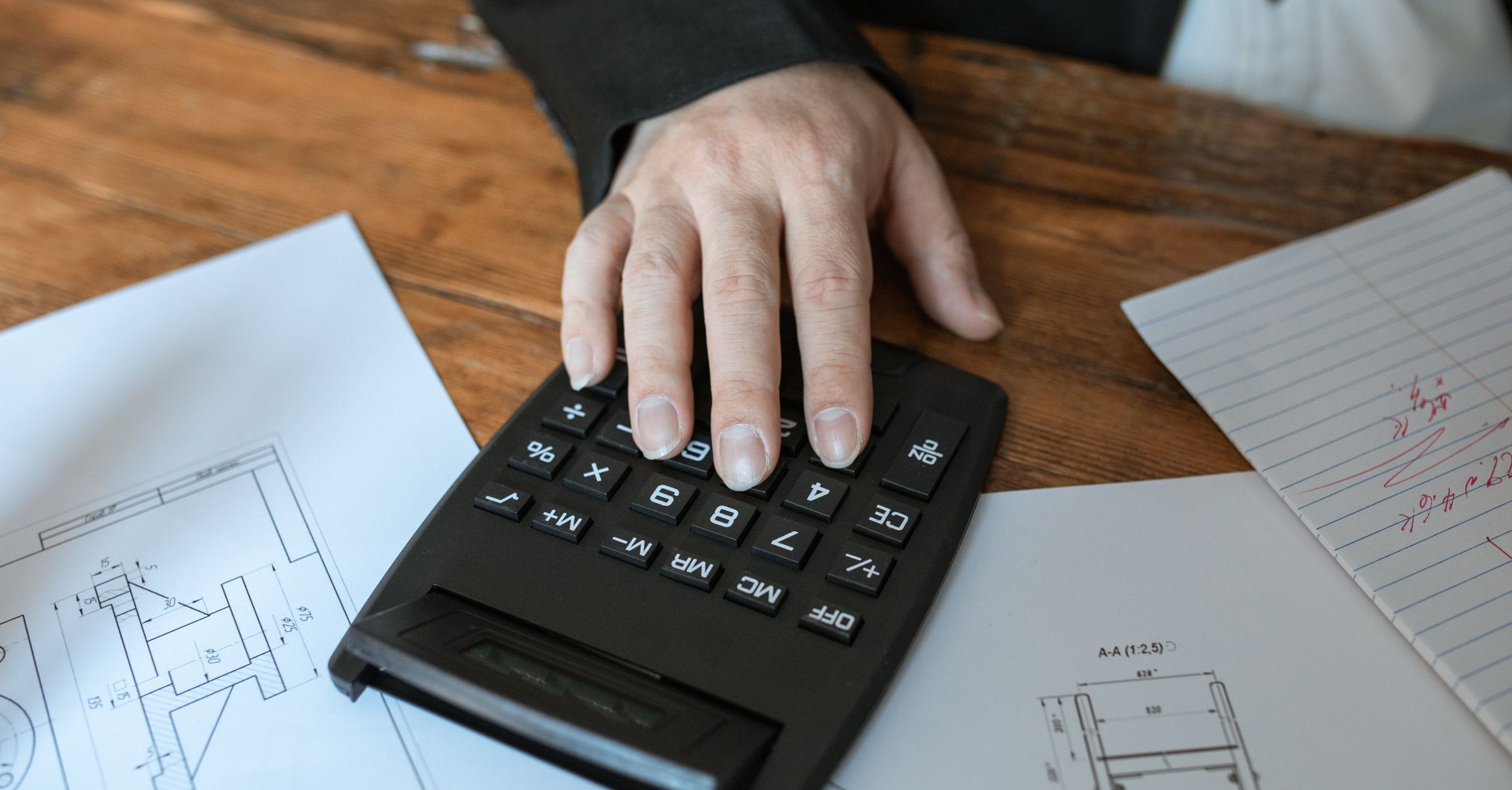 Calculator on architectural blueprints for construction takeoff and billing